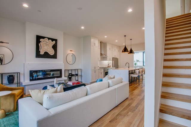 living room featuring light wood-type flooring and sink