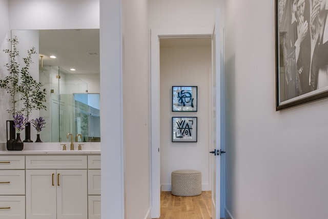 bathroom with vanity, an enclosed shower, and wood-type flooring