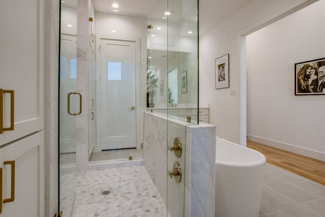 bathroom featuring hardwood / wood-style flooring and plus walk in shower