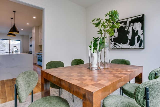 dining space with hardwood / wood-style floors and sink