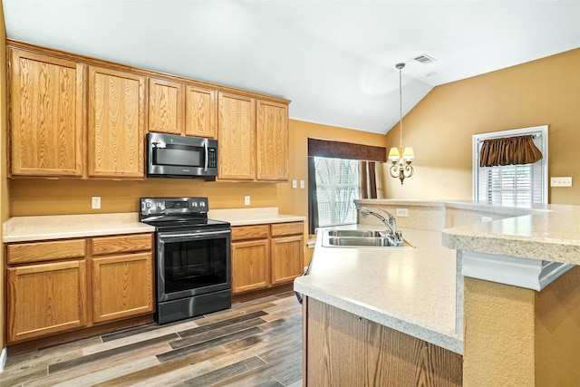 kitchen with black electric range, hardwood / wood-style floors, vaulted ceiling, and a healthy amount of sunlight