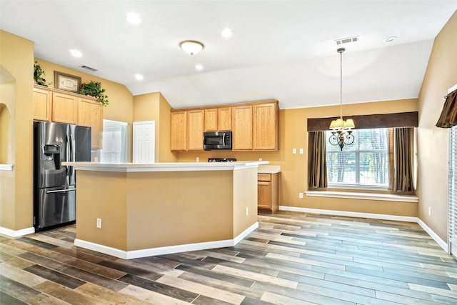 kitchen featuring stainless steel appliances, lofted ceiling, a kitchen island, and dark hardwood / wood-style flooring