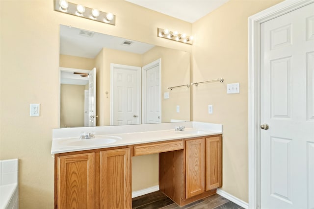 bathroom with hardwood / wood-style floors, a tub, and vanity