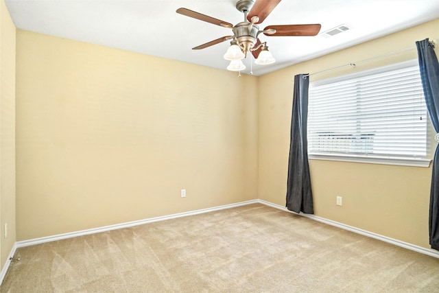 spare room featuring light colored carpet and ceiling fan