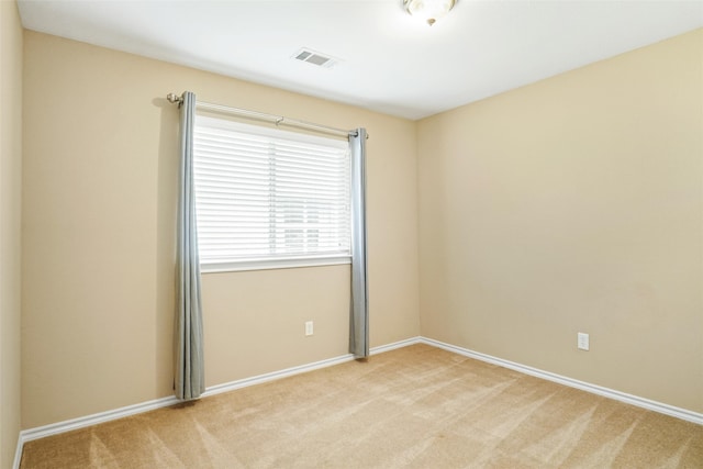 spare room featuring light colored carpet