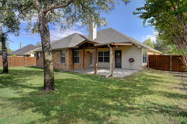 back of house with a patio and a yard