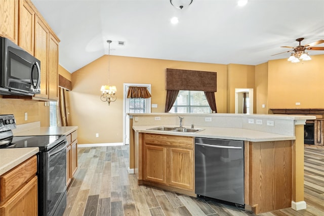 kitchen with appliances with stainless steel finishes, decorative light fixtures, sink, vaulted ceiling, and light hardwood / wood-style flooring