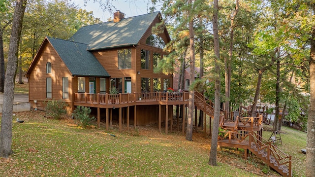 rear view of property featuring a deck and a lawn