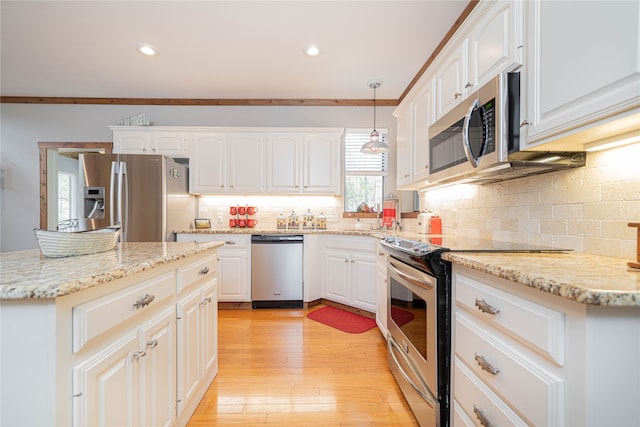 kitchen with light hardwood / wood-style floors, white cabinets, crown molding, pendant lighting, and appliances with stainless steel finishes