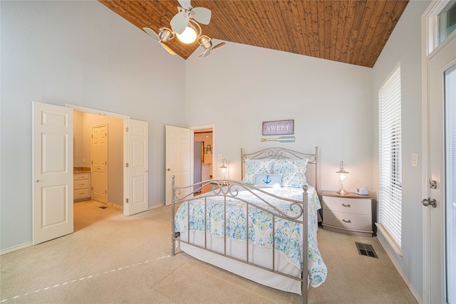 carpeted bedroom with wooden ceiling, ceiling fan, ensuite bath, and high vaulted ceiling