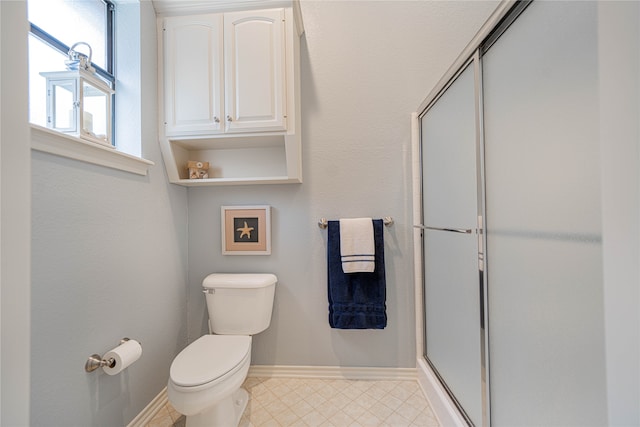 bathroom featuring toilet and an enclosed shower