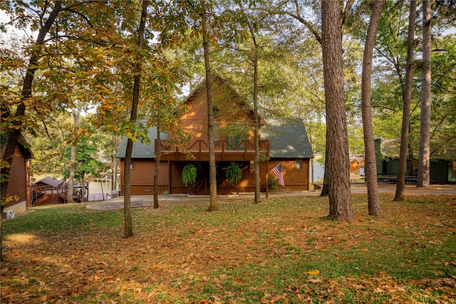 rear view of property with a wooden deck, a lawn, and a patio area