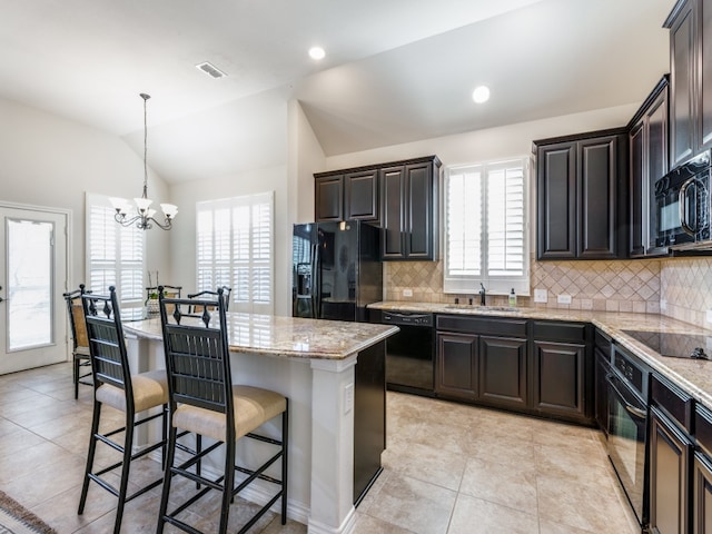 kitchen featuring black appliances, lofted ceiling, a center island, and plenty of natural light