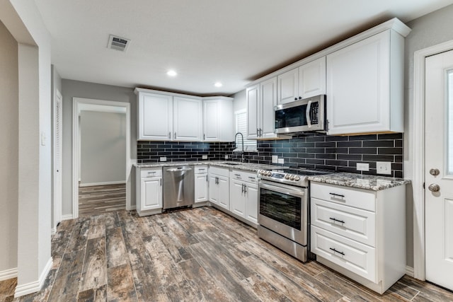 kitchen with white cabinets, dark hardwood / wood-style floors, and stainless steel appliances