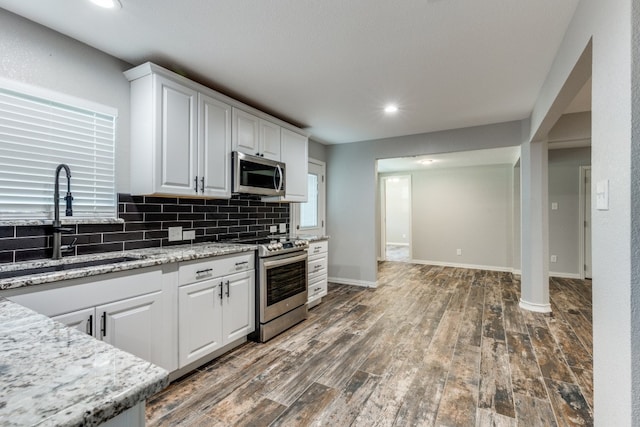 kitchen with stainless steel appliances, white cabinets, sink, and dark hardwood / wood-style flooring