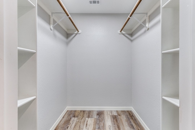 spacious closet with hardwood / wood-style floors