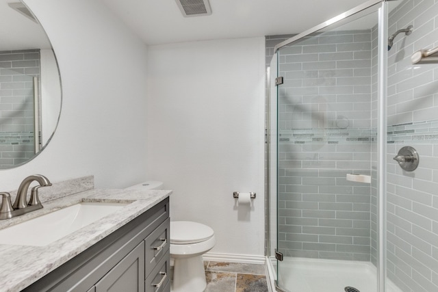 bathroom featuring an enclosed shower, vanity, and toilet