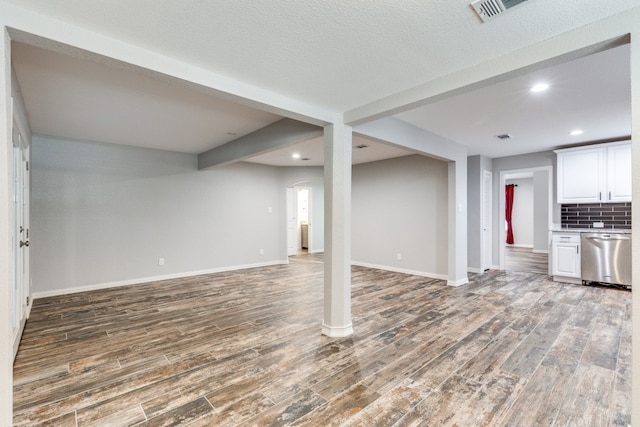 basement with hardwood / wood-style floors and a textured ceiling