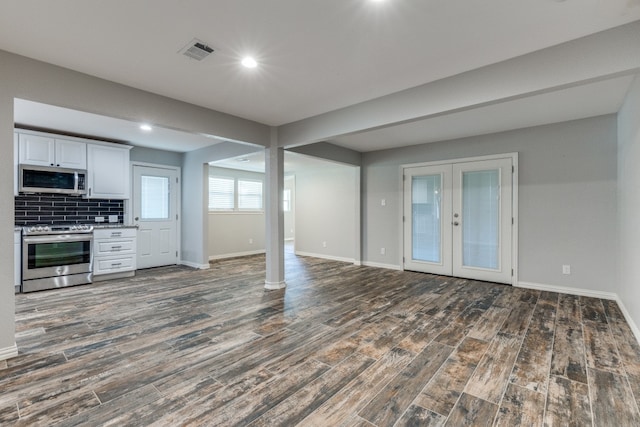 interior space with stainless steel appliances, dark hardwood / wood-style floors, white cabinets, and backsplash