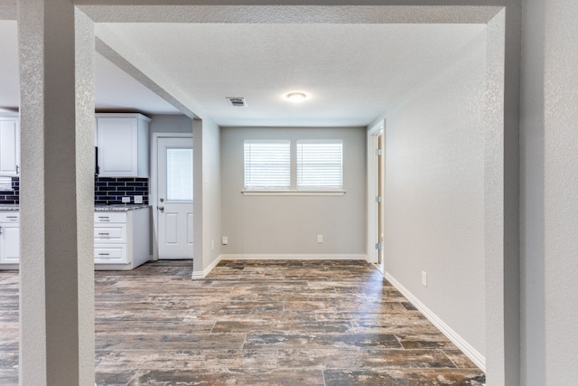 entryway featuring dark wood-type flooring and a textured ceiling