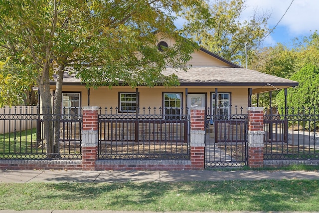 view of front facade featuring a fenced front yard, a porch, and roof with shingles