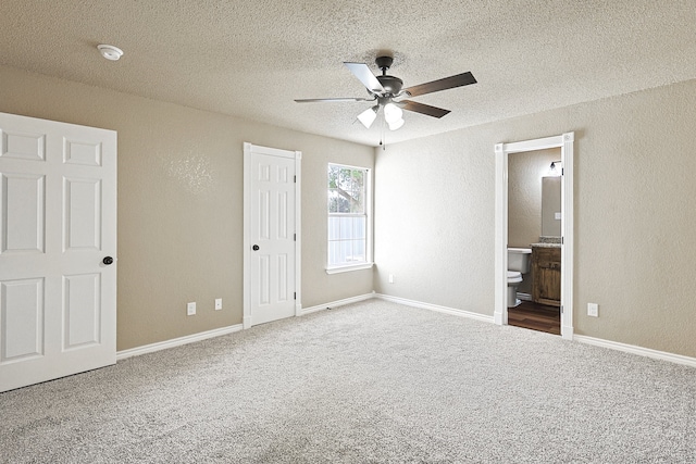 unfurnished bedroom with a textured ceiling, baseboards, carpet flooring, and a textured wall