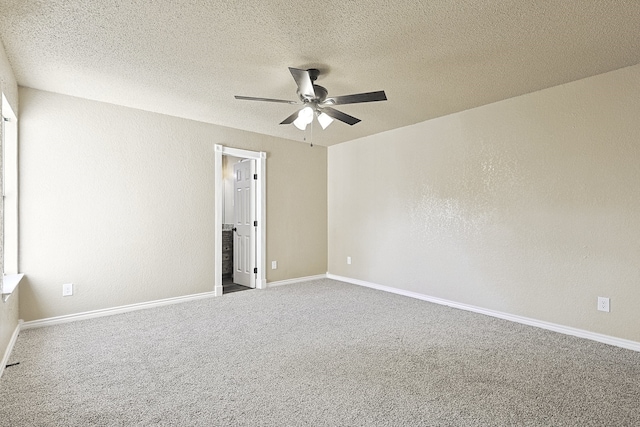 carpeted spare room with ceiling fan, a textured wall, a textured ceiling, and baseboards