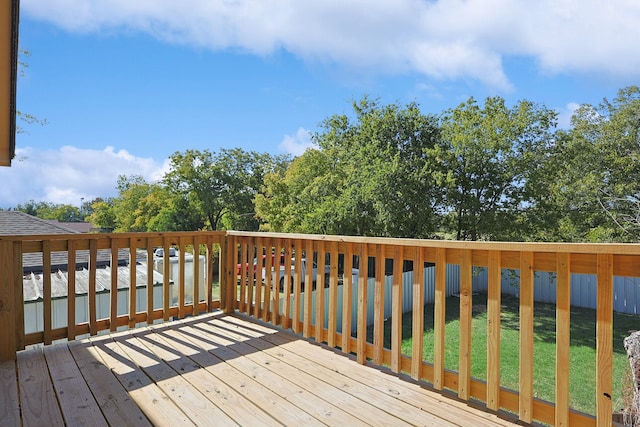 wooden deck featuring a lawn