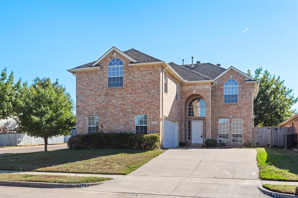 view of property with a garage and a front lawn