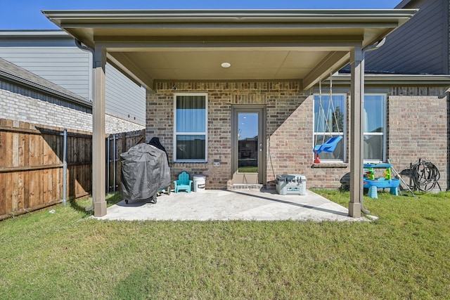 rear view of house featuring a lawn and a patio area