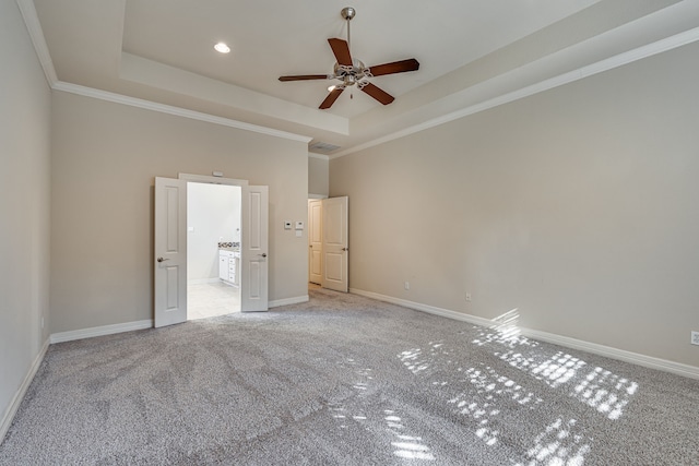 unfurnished bedroom featuring a tray ceiling, light carpet, and ceiling fan