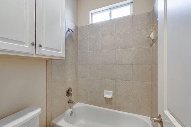 bathroom featuring toilet and tiled shower / bath