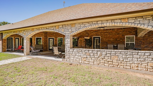 back of property with a yard and a patio