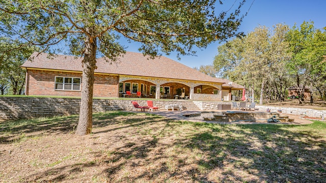 rear view of house featuring a yard and a patio area