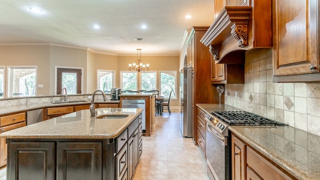 kitchen featuring a kitchen island with sink, appliances with stainless steel finishes, light stone counters, and plenty of natural light