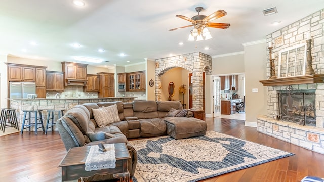 living room with ceiling fan, dark hardwood / wood-style floors, ornamental molding, and decorative columns