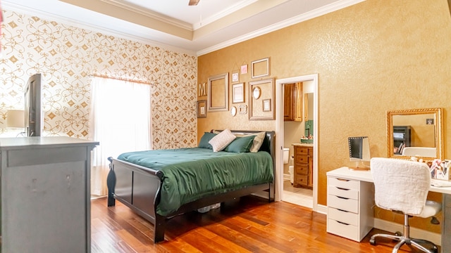 bedroom featuring connected bathroom, ceiling fan, hardwood / wood-style floors, and ornamental molding