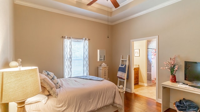 bedroom with ornamental molding, ensuite bath, hardwood / wood-style flooring, and ceiling fan