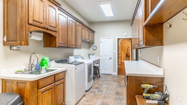 washroom with cabinets, separate washer and dryer, and sink