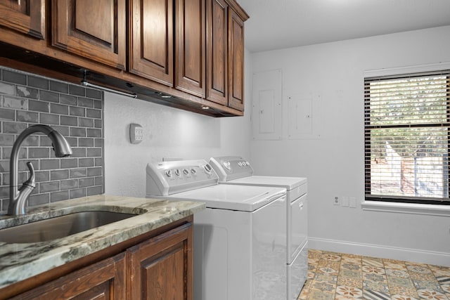 clothes washing area with cabinets, a wealth of natural light, sink, and washing machine and clothes dryer