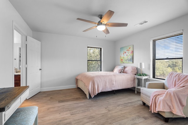 bedroom with light wood-type flooring, multiple windows, and ceiling fan