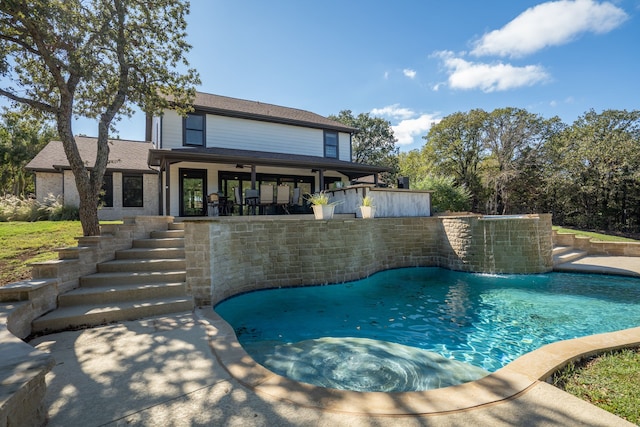 view of pool featuring pool water feature and a patio