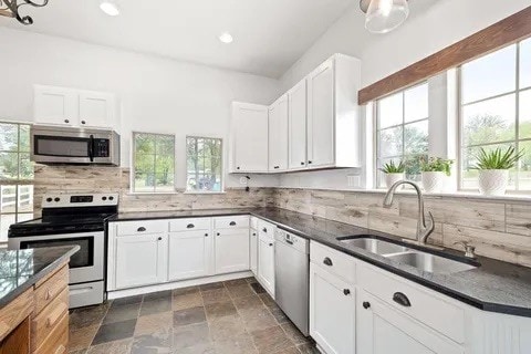 kitchen with white cabinets, sink, a healthy amount of sunlight, and stainless steel appliances