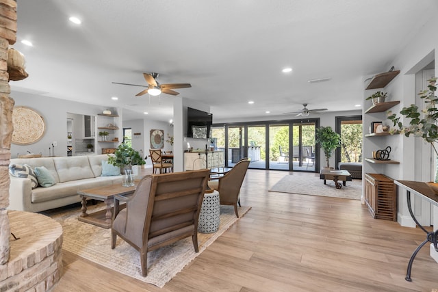 living room with light wood-type flooring and ceiling fan