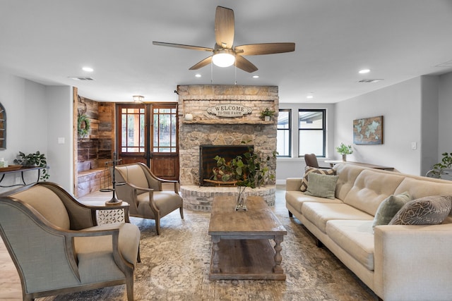 living room with a fireplace, ceiling fan, and hardwood / wood-style floors