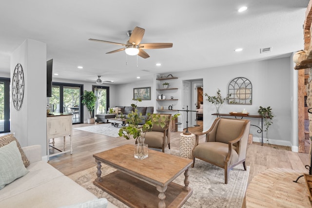 living room featuring ceiling fan and light hardwood / wood-style flooring