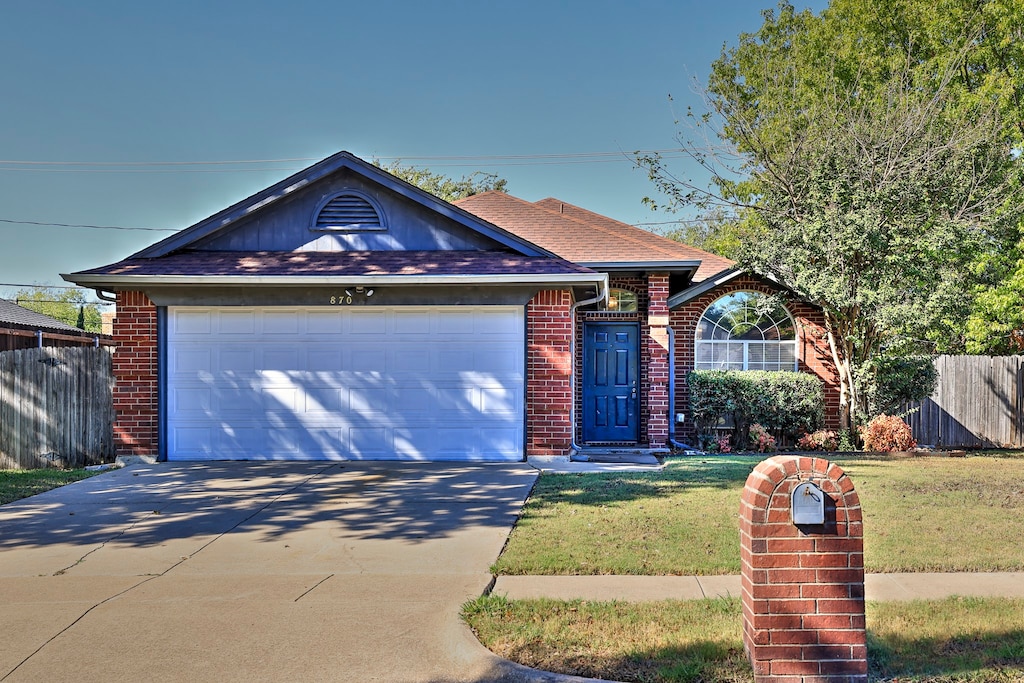 single story home featuring a front lawn and a garage