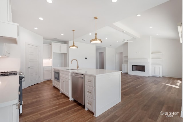 kitchen featuring sink, stainless steel appliances, vaulted ceiling with beams, a center island with sink, and white cabinets