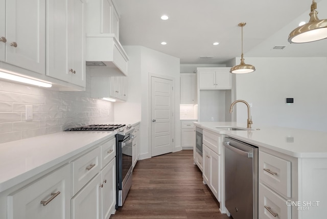 kitchen with pendant lighting, white cabinets, sink, appliances with stainless steel finishes, and tasteful backsplash