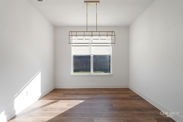 7813 Langford Dr, Abilene, TX 79606 - spare room featuring a chandelier, wood finished floors, and baseboards